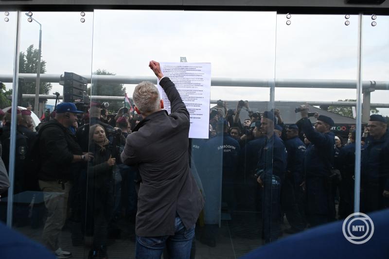 Magyar Péter, a Tisza Párt elnöke 16 pontos követelést tartalmazó papírlapot helyez ki a párt demonstrációján az MTVA óbudai székházának bejáratában 2024. október 5-én. MTI/Koszticsák Szilárd