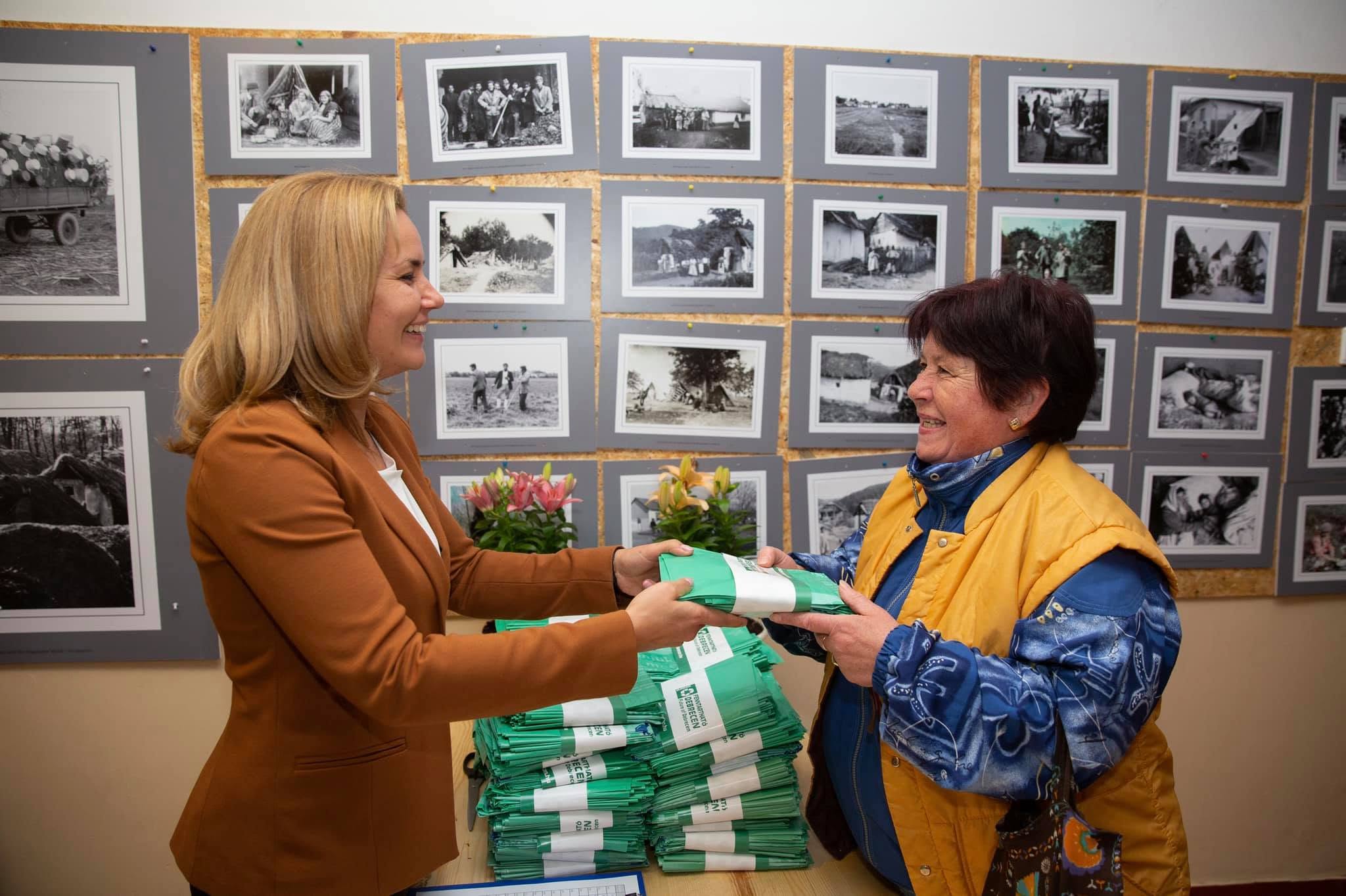 Széles Diána lombgyűjtő zsákot ad át
